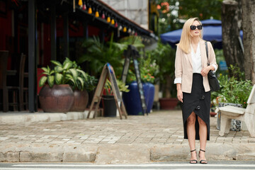 Elegant Woman Standing on Pavement