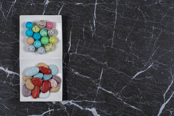Delectable candies in bowl, on the marble background