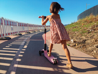 scooter, safety helmet. Close up feet of girl riding e scooter in urban environment. Fashion woman on electric scooter in city park

