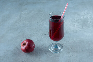 Red tasty juice with fresh apple and straw