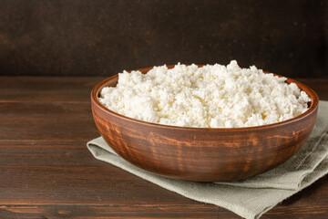 Cottage curd cheese in a wooden bowl on wooden table