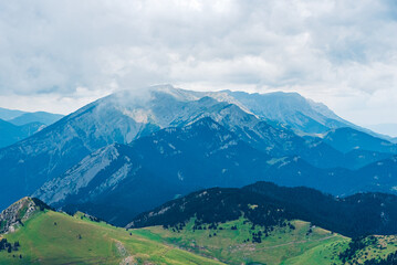 Obraz premium Clouds and fog over the green mountains.