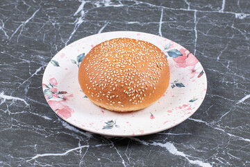 Homemade hamburger buns with sesame on the plate , on the marble background