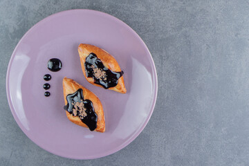 Delicious sweet triangle pastry on a purple plate