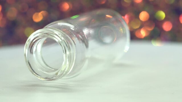 Glass bottle rotates in front of bokeh background