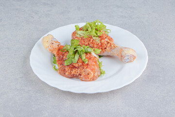 Raw spicy chicken legs in the plate, on the white background