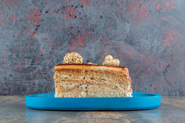 Slice of caramel cake on blue plate