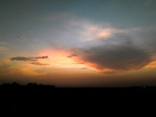 Beautiful sunset scenery view, sunrays shining behind the clouds in sky, nature photography, natural background