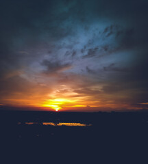 Obraz premium Beautiful sunset scenery view, sunrays shining behind the clouds in sky, nature photography, natural background