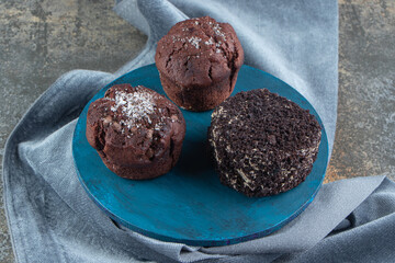 A blue wooden board with chocolate cakes