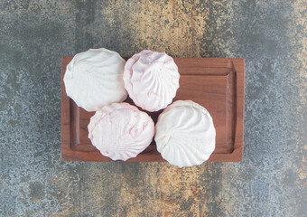 A wooden board of delicious sweet dessert white zephyr marshmallows