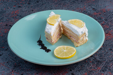 Lemon cake with sugar powder in the blue plate on colorful background