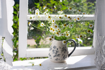 Bouquet of daisies on window sill. Window is opened.
