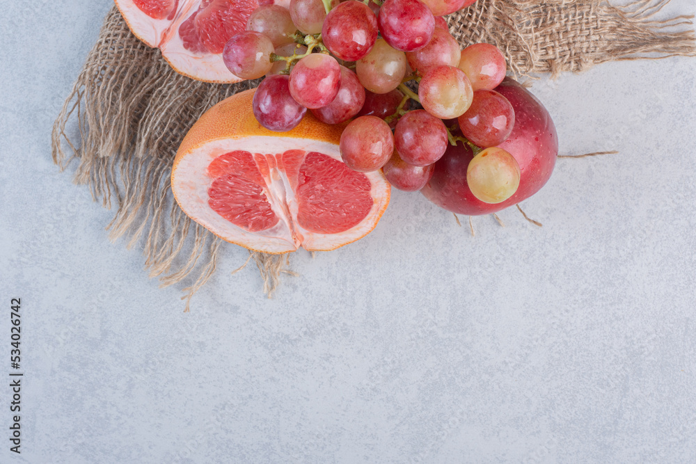 Wall mural Fresh season fruits apple grape and grapefruit on grey background