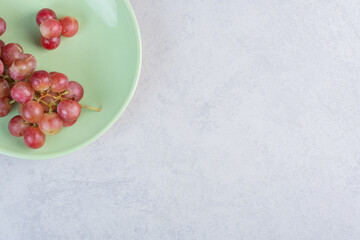 Obraz na płótnie Canvas Fresh organic red grapes on green plate