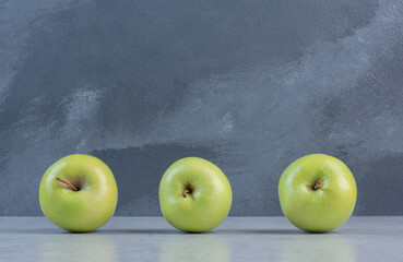 Close up photo of three green fresh apples