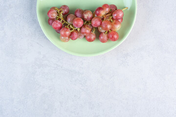 Red grape bunch on green plate