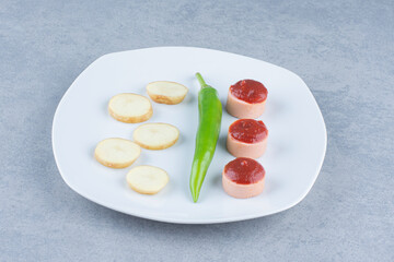 Fried potato and spicy sausage on white plate