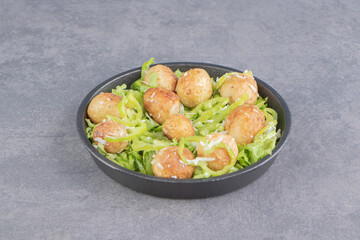 Delectable lettuce leaves and sausage, on the plate , on the marble background