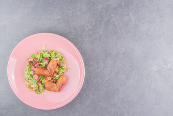 Toothsome salad with sausage , on the marble background