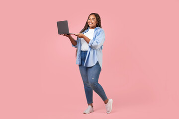 Cheerful Black Overweight Freelancer Lady Using Laptop Over Pink Background