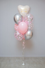 a set of pink balloons on a gray wall background, birthday helium balloons, the inscription on the balloon "Happy birthday beauty"