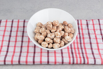 Cinnamon cookies in the plate on the towel on the marble background