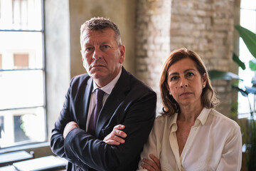 Two empowered businessmen standing together in company boardroom