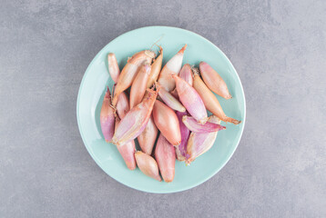 Plate full of onions on the marble background
