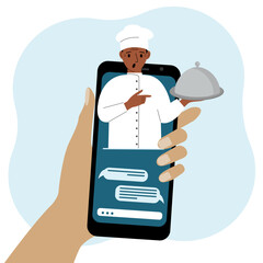 Online food shopping on mobile phone or fast food delivery order. The cook holds a tray with a lid or a plate with a cloche.