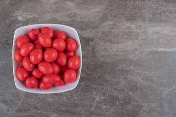 Sweet confectionery in the bowl , on the marble background