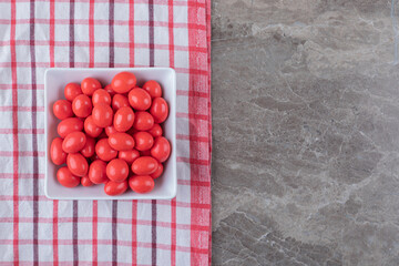 Toothsome candy in the cup, on the towel, on the marble background