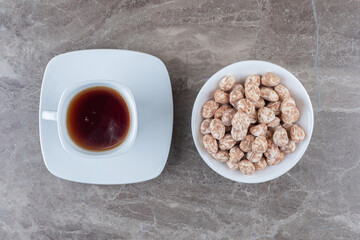 A cup of tea and confectionery on the marble background