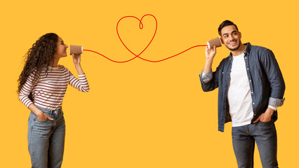 Woman Sending Love Message To Boyfriend Through Phone With Heart Shaped String