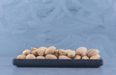 A tray of tasty almonds , on the marble background
