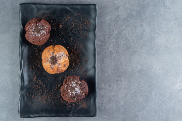 Chocolate muffins with nut muffin on a dark board