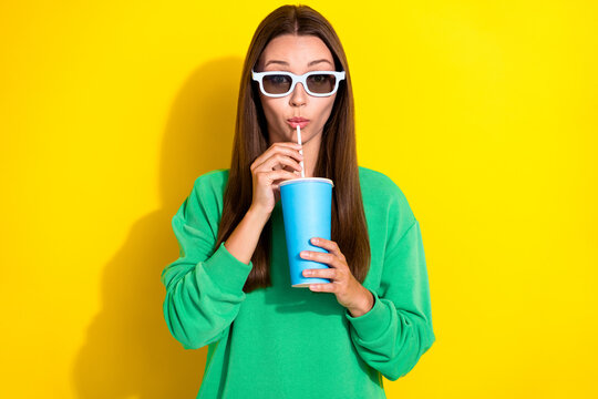 Portrait of nice young lady hands hold sipping drink cup straw isolated on yellow color background