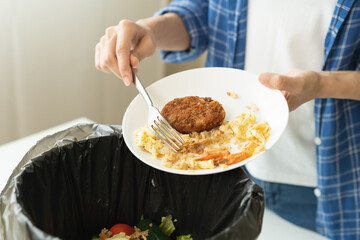 Compost from leftover food, refuse asian young housekeeper woman, girl hand using fork scraping waste from dish, throwing away putting into garbage, trash or bin..Environmentally responsible, ecology.