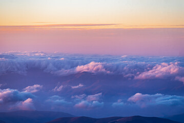 Obraz premium Panoramic view form mountains peak on the fog and clouds. Sunrise landscape. 