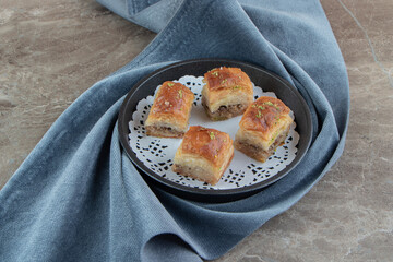 Four delicious baklava on dark plate