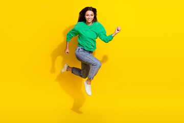 Fototapeta na wymiar Full size photo of cute young unstoppable woman smile running marathon dressed trendy green sweatshirt isolated on yellow color background