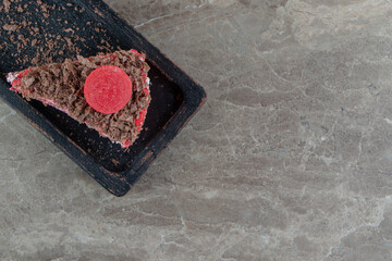 Slice of tasty cake on dark plate