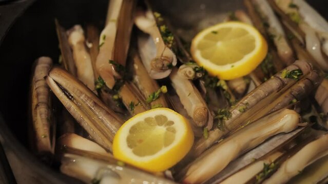Razor clams seafood grilled on market, grill Spanish Navajas, traditional food in Spain, Catalonia, Barcelona.