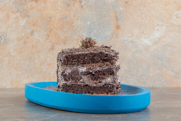 Slice of chocolate cake on blue plate