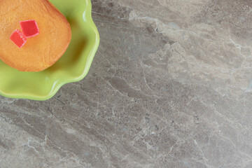 Sweet cake with candies in green bowl