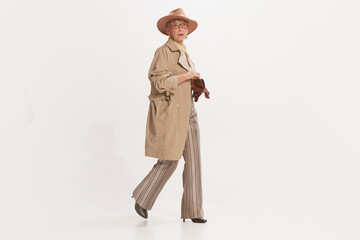 Portrait of beautiful senior woman in retro vintage style outfit posing isolated on white background. Concept of beauty, old generation, fashion, emotions