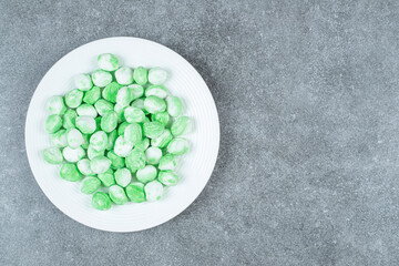 Hard green candies on white plate