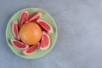 A serving of grapefruit on a platter on marble background
