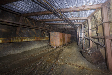 Fototapeta na wymiar Tunnel of closed coal mine with railway track.