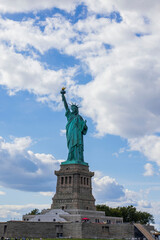 Fototapeta premium Close-up view of Statue of Liberty on Liberty Island in New York against blue sky with white clouds. 
